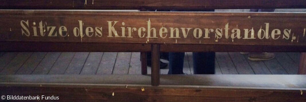 Bank mit der Aufschrift "Sitze des Kirchenvorstandes"